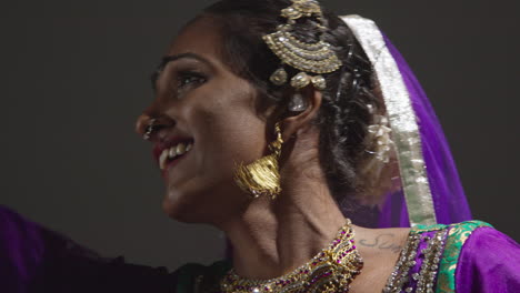 primer plano de una bailarina de kathak femenina realizando un baile vestida con un vestido tradicional indio sentada en el suelo en el centro de atención 2