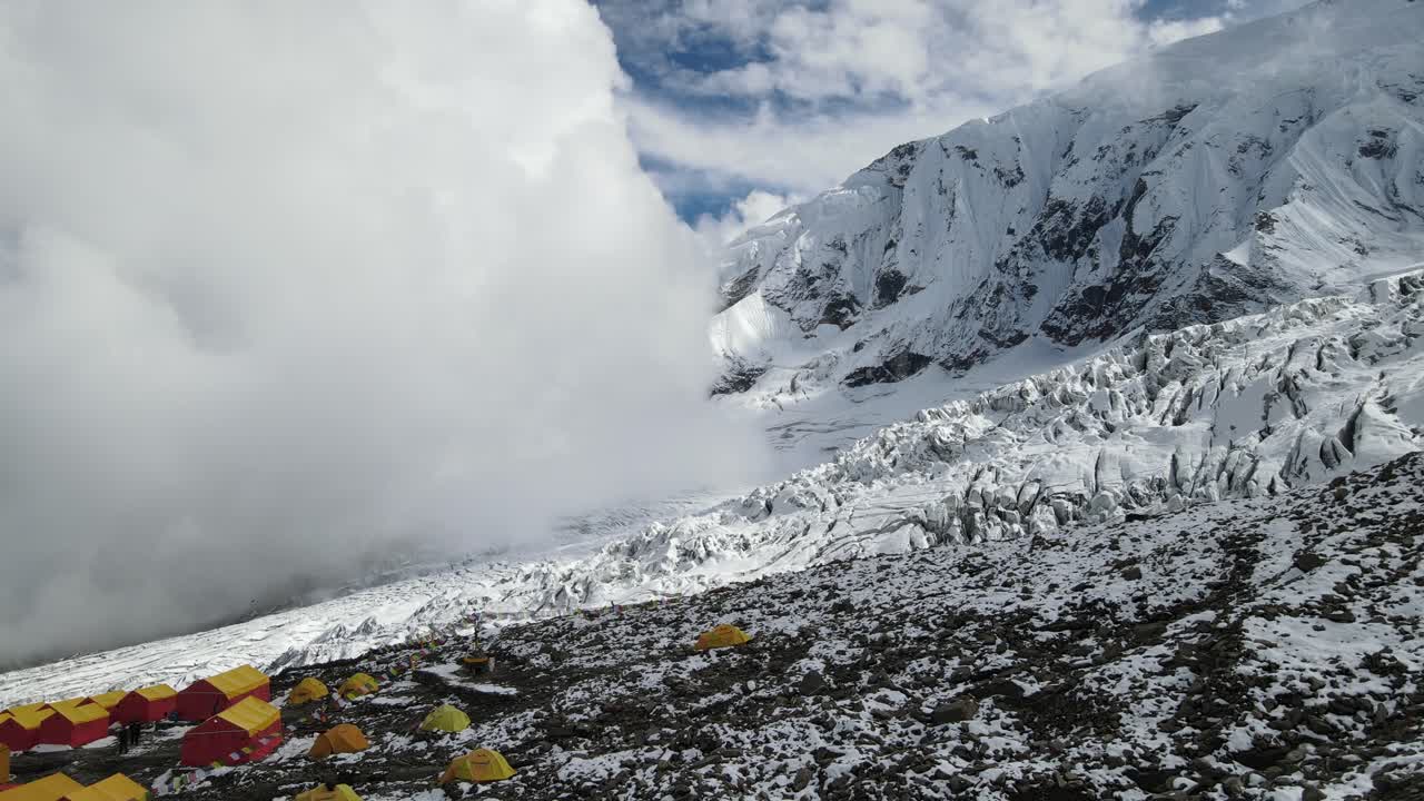 Drone footage showcases Manaslu Base Camp below the 8,163m Himalayan peak. The scene reveals snowy ridges, rugged terrain, and the dramatic high-altitude environment of this remote mountain region