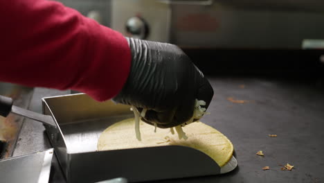 warming corn tortilla shells to melt cheese for a mulita - food truck series