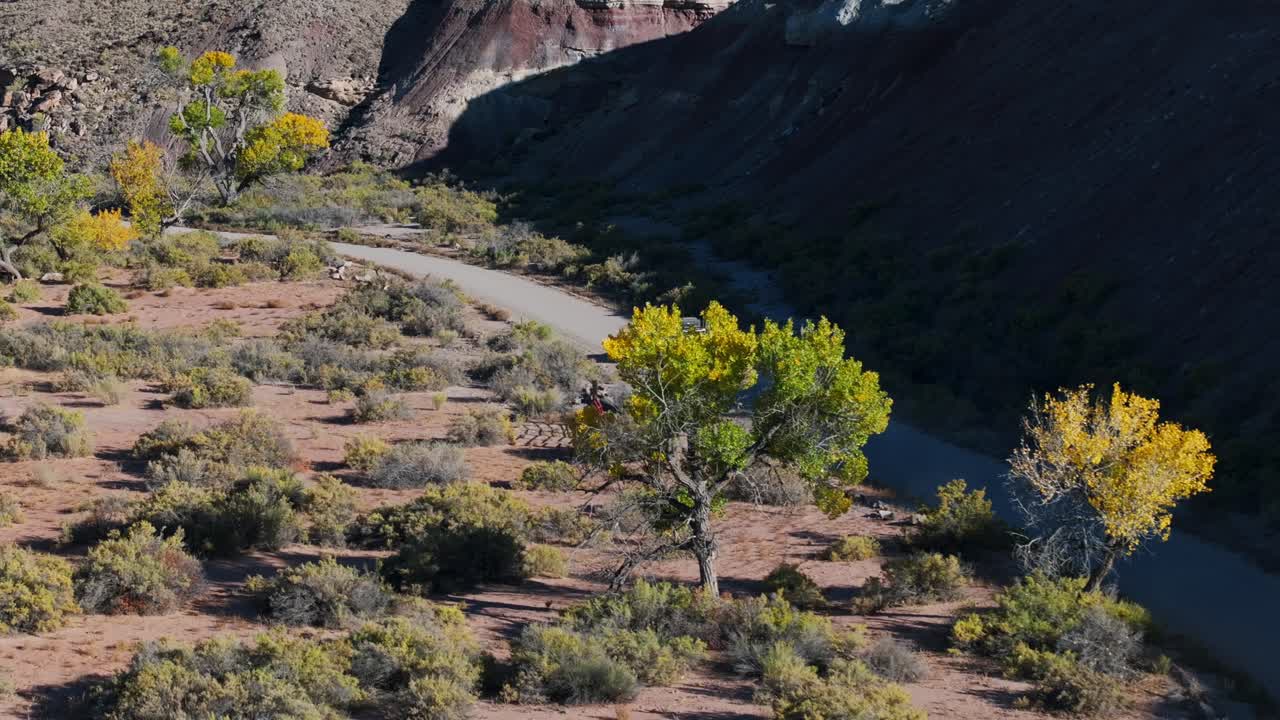 fotografía aérea de un suv blanco conduciendo por la carretera a través de las praderas de utah