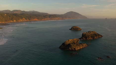 sea stacks at sunlight near port orford with humbug mountain in background