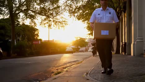 security guard delivering package at sunset