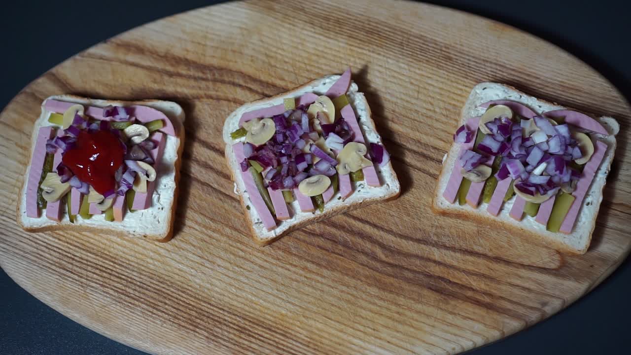 agregando salsa de tomate a sándwiches con champiñones, pepinillos y tiras de salchicha