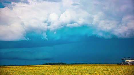 farmers working with combine in fields while thunder storm forming above, time lapse