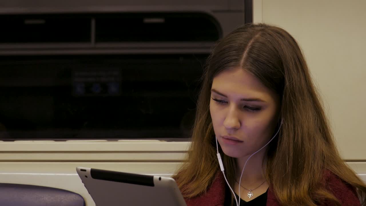 Giovane donna che usa il tablet sul treno