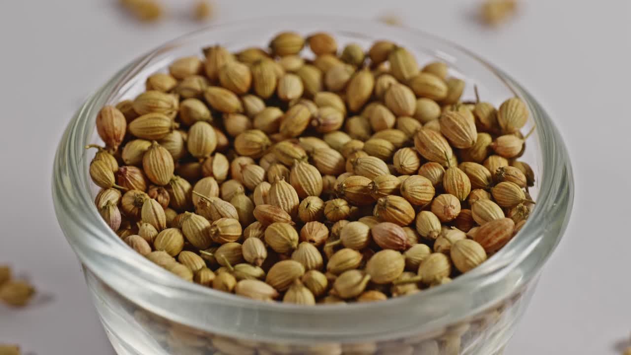 coriander seeds in small glass bowl, closeup, 4k, parallax shot.
