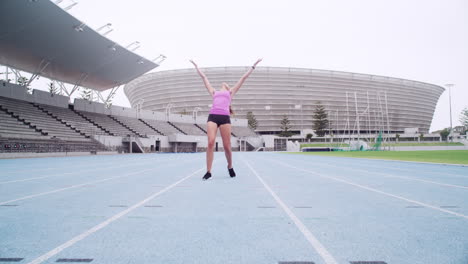 a female athlete cheering while out on the track