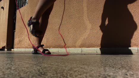 Close up of a girl&#039;s legs jumping with a rope