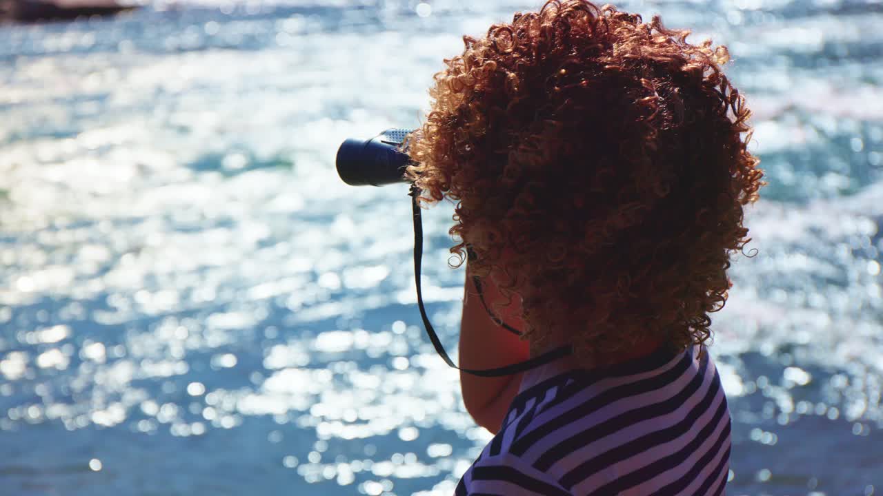 Child with Binoculars Looking at a River