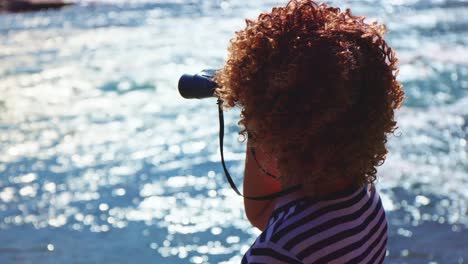 child with binoculars looking at a river