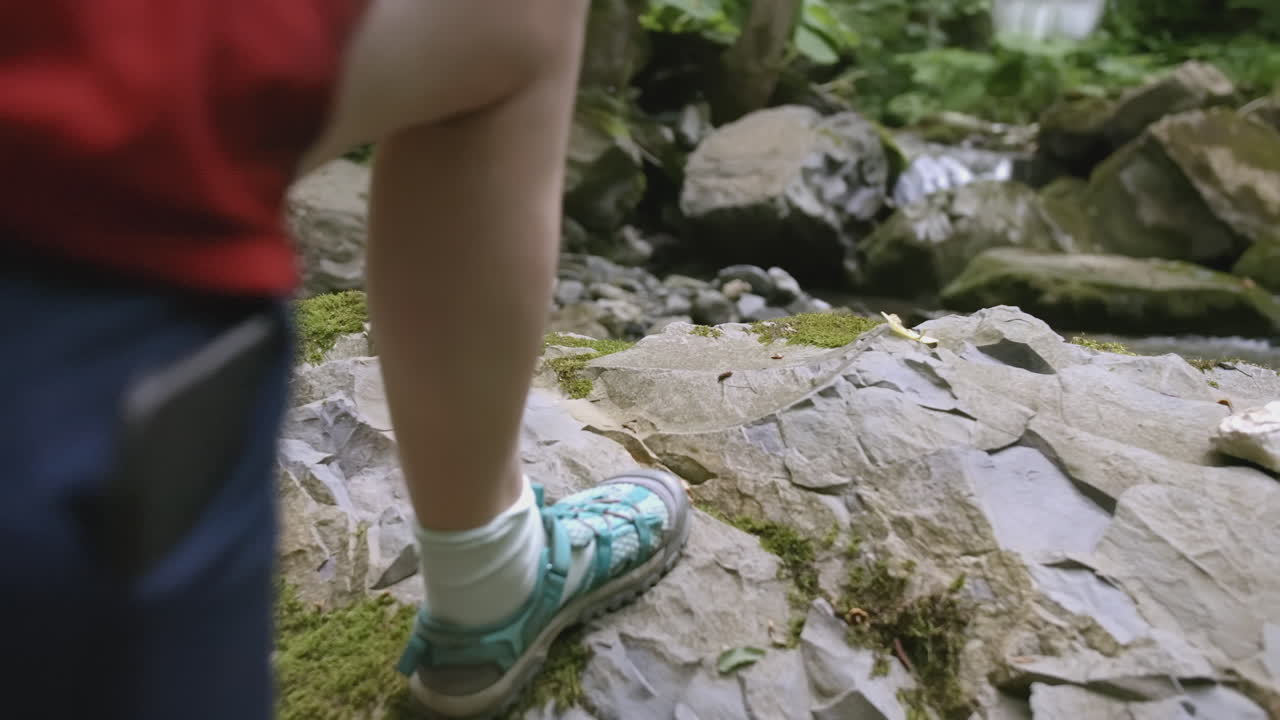 女子涉水穿越崎嶇溪流
