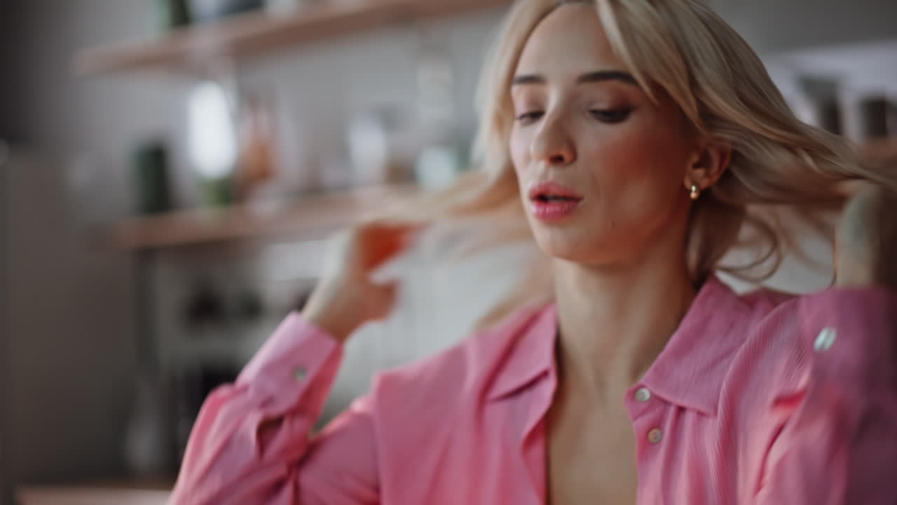 Exhausted blonde rubbing neck experiencing fatigue at kitchen interior portrait