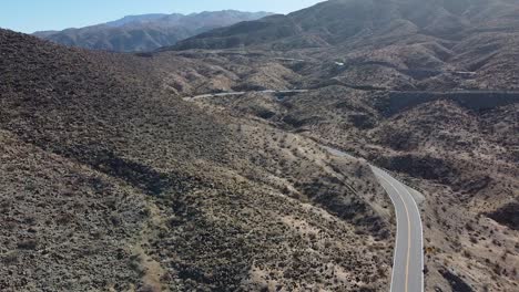 Paisaje-Montañoso-Del-Desierto-Y-Carretera-Sinuosa,-Toma-Aérea-Ascendente