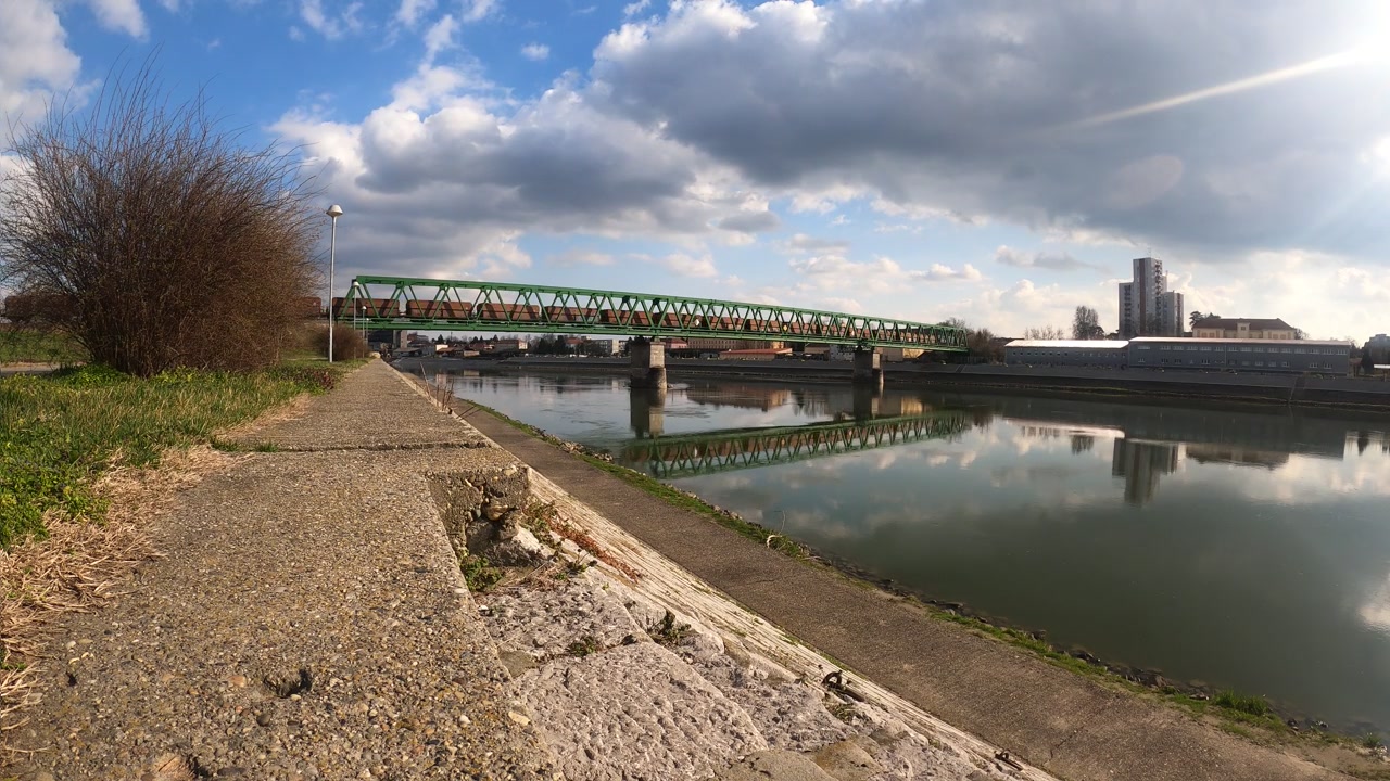 Il treno attraversa il ponte sul fiume. Timelapse. OSIJEK, CROAZIA