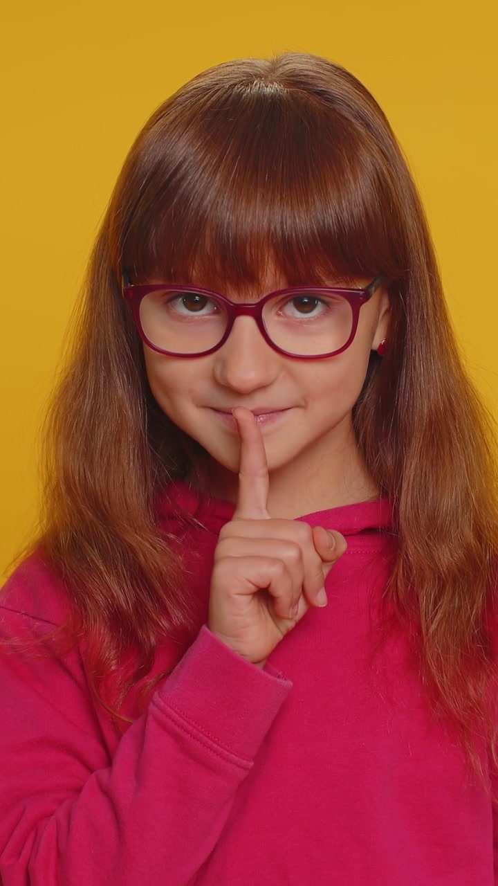 Ragazza preadolescente preme il dito sulle labbra fa silenzio segno di silenzio non dice pettegolezzi segreto silenzio