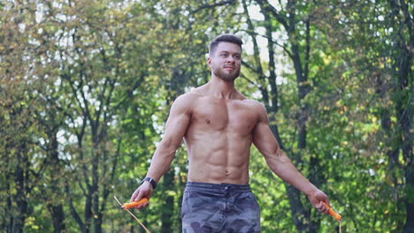 man exercising with jump rope. athletic sportsman jumping on skipping rope in park