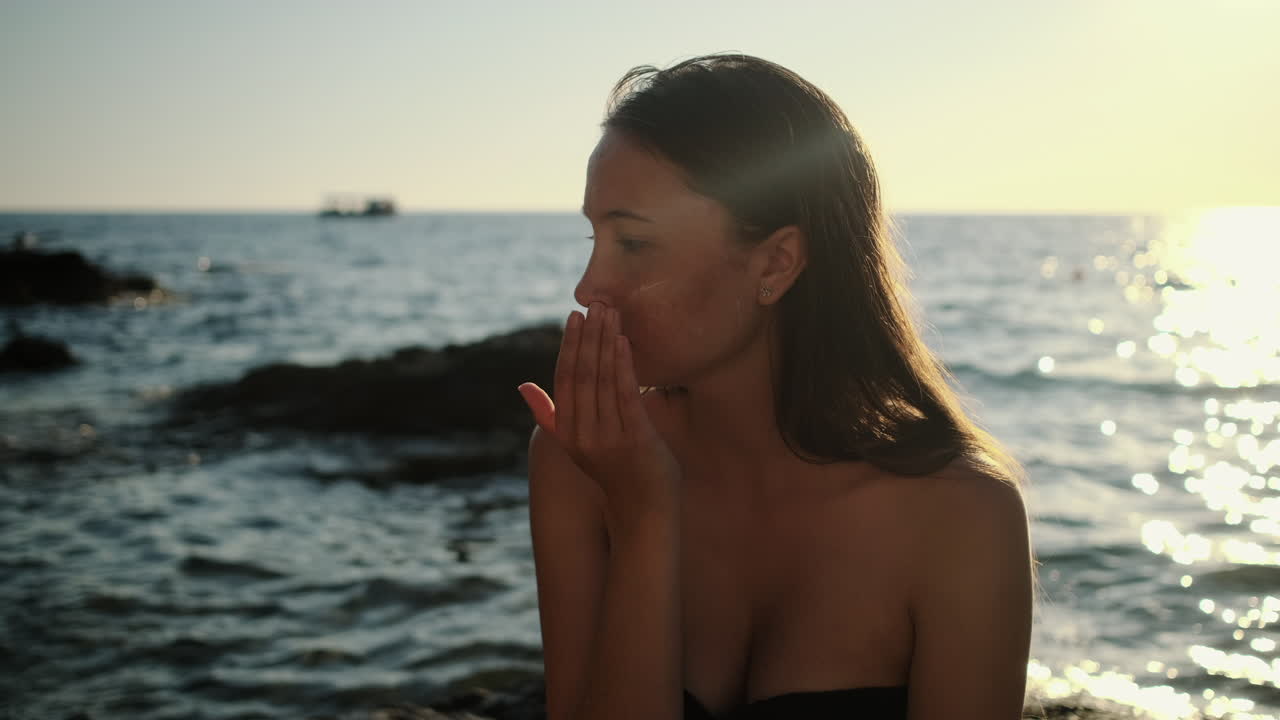 해변 에서 해가 지는 때 자외선 차단제 를 적용 하는 여자