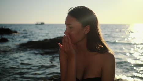 mujer aplicando protector solar al atardecer en la playa