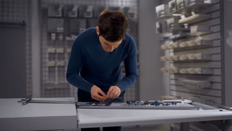 man assembling electronic components in a workshop