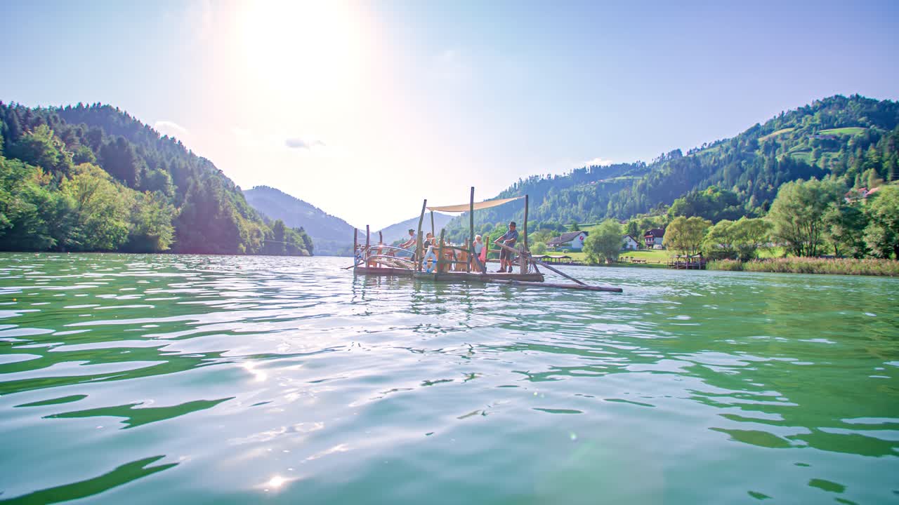 Scenic Hlodovc log-raft floating down the Drava river between mountains, Muta, Slovenia