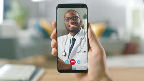 punto de vista: hombre que usa un teléfono inteligente para hablar con su médico a través de una aplicación médica de videoconferencia. persona revisa los síntomas, habla con el médico, usando una aplicación de video chat en línea. cámara pov de primer plano.