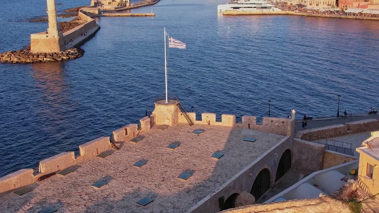 Vista aerea del vecchio porto veneziano di Chania con faro e bandiera greca