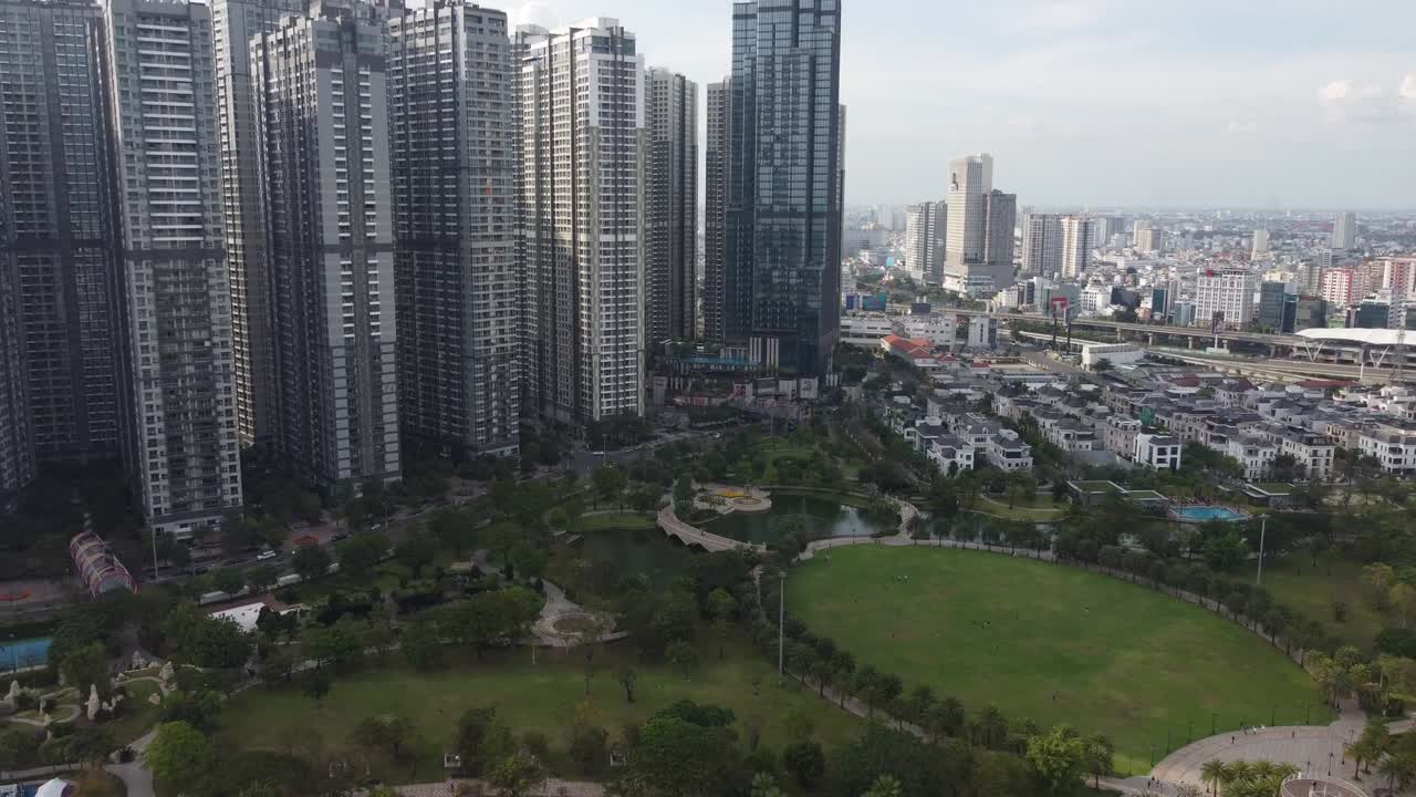 Drone video captures Bình Thạnh's lush gardens amid towering skyscrapers in Ho Chi Minh City under soft daylight, showcasing urban green spaces and residential high-rises