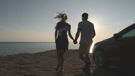 the couple running to the mountain cliff on the seascape background. slow motion