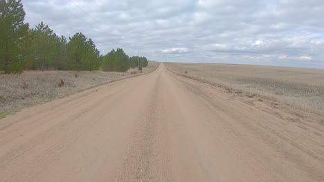 Sicht-Fahren-Auf-Einer-Geraden-Schotterstraße-Im-Ländlichen-Nebraska-An-Einem-Bewölkten-Wintertag