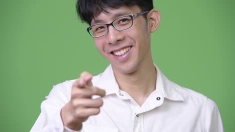 young asian businessman smiling and pointing to camera