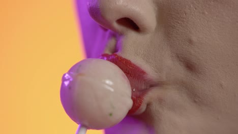 woman licking popsicle, licking lipstick lips, mouth close-up shot on yellow background