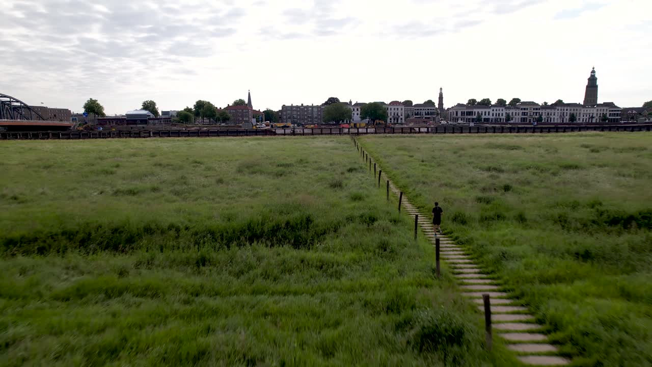 남성 트레일 러너의 공중 추적 네덜란드 홍수 평야와 타워 타운 zutphen의 얼굴 뒤에 ijssel 강을 따라