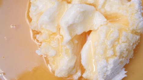 close up of creamy white cheese spread with a drizzle of honey