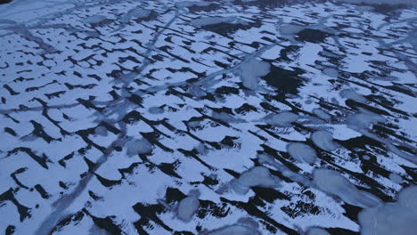 overhead drone view traversing the frozen waters of lake michigan