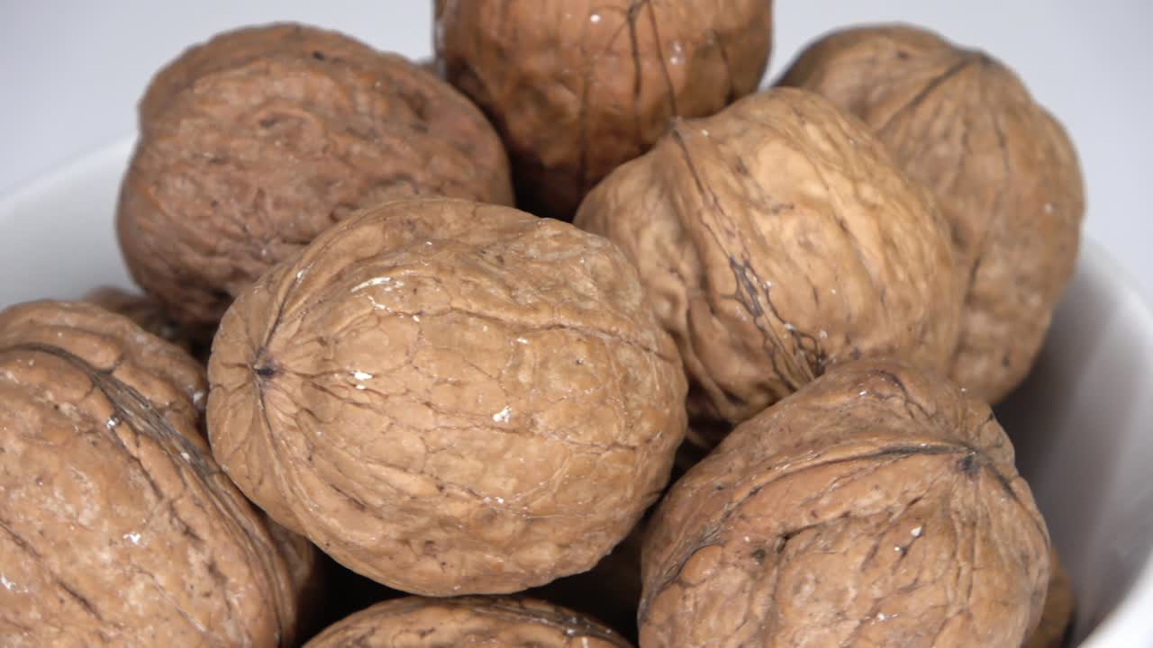 algunas nueces en un cuenco giran lentamente en un círculo - video en bucle