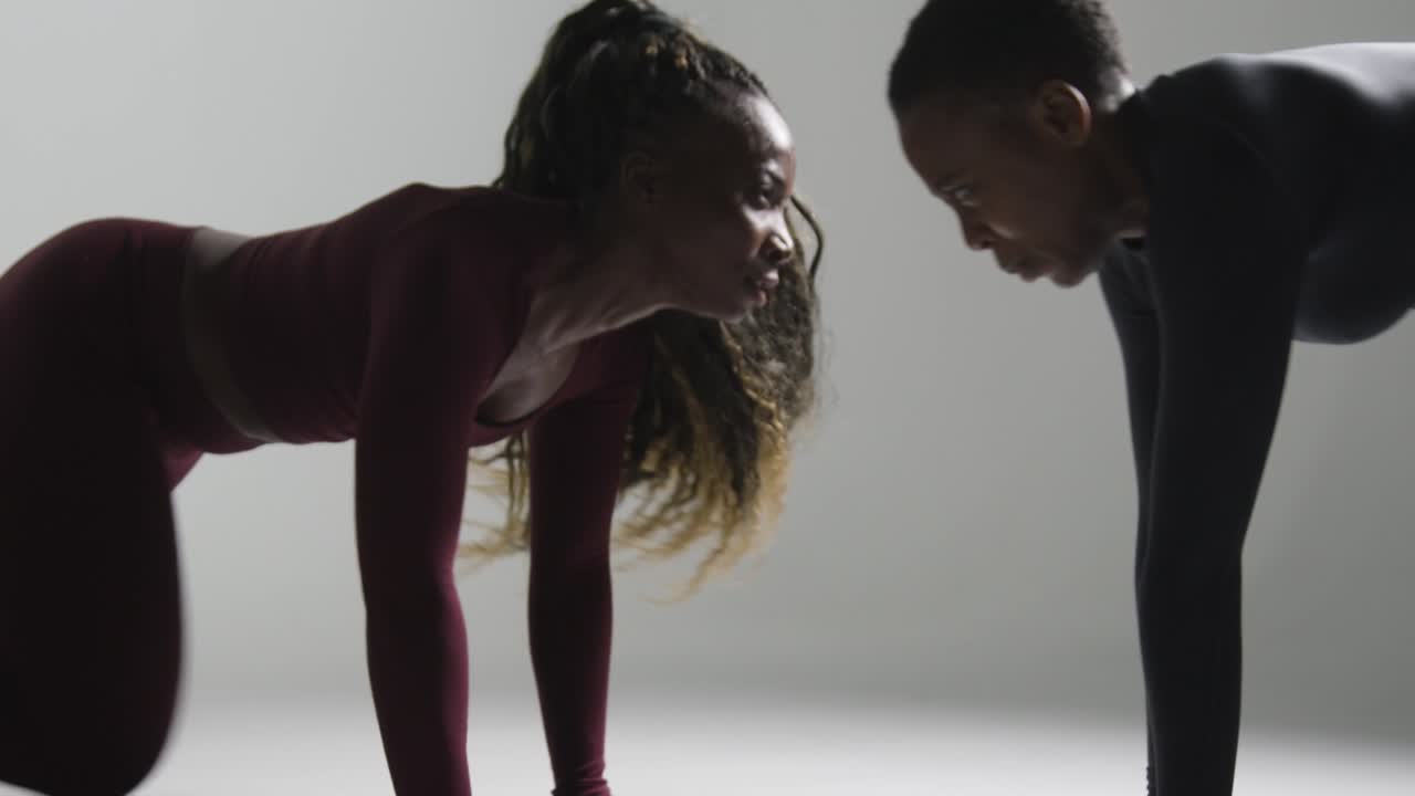 fotografía de estudio de dos mujeres vestidas con ropa de gimnasia frente a frente haciendo ejercicio 6