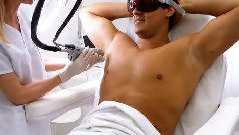 Doctor-performing-laser-hair-removal-on-male-patient-skin