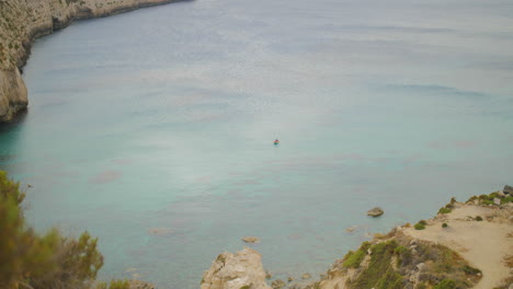 A-Boat-in-Mediterranean-Sea-Water-by-Scenic-Coastline-of-Malta,-Fomm-Ir-Rih-Bay