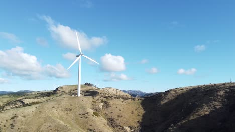 a static aerial shot of a wind turbine on a hill