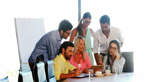 Businesspeople-having-a-discussion-while-using-digital-tablet