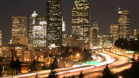 accelerated traffic blurs into streaks of light before an illuminated seattle skyline