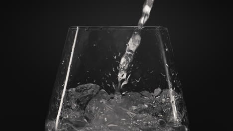 ice water pouring wineglass closeup. preparing refreshing cocktail concept