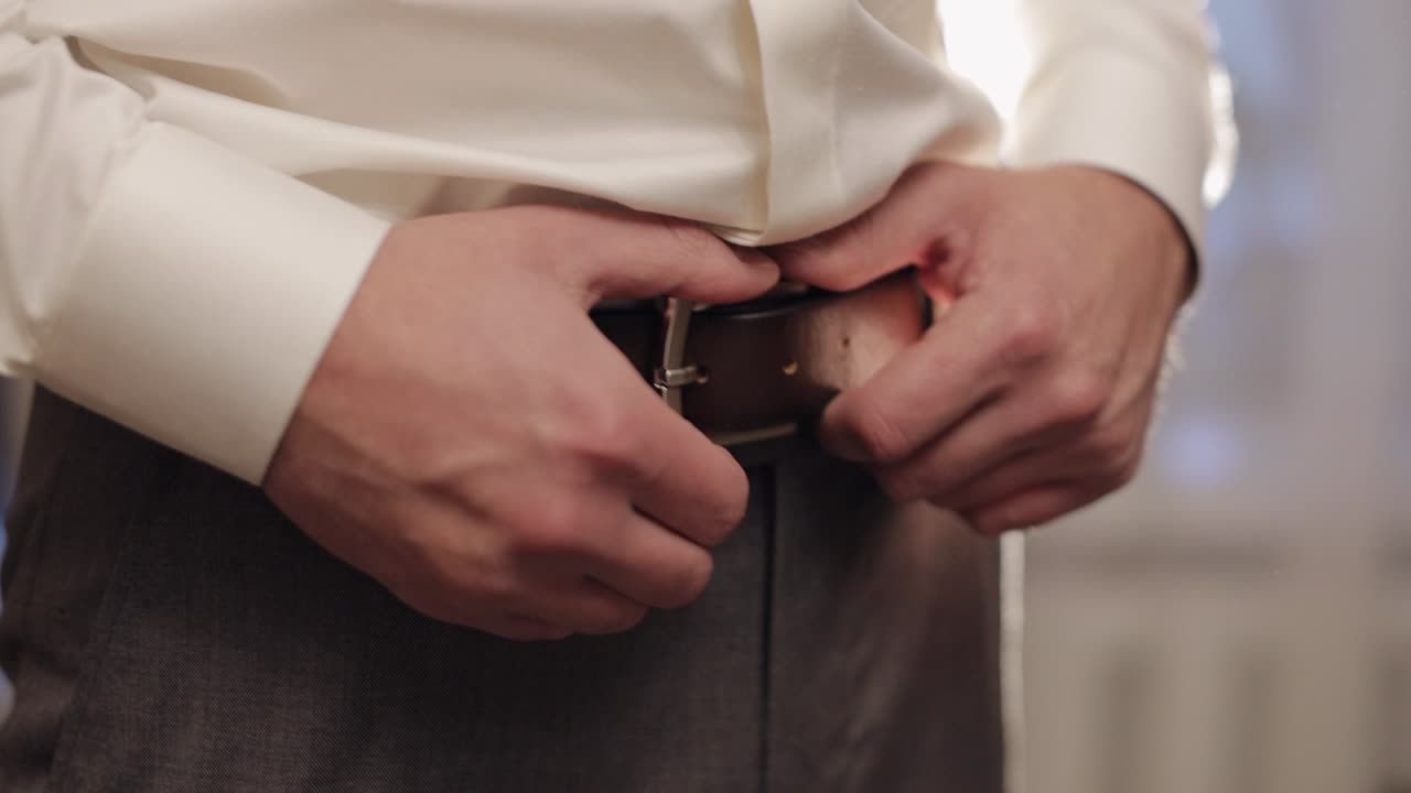 신부는 벨트를 입고,  셔츠를 입은 남자는 결혼식 아침에 바지를 입고, 사업가 준비