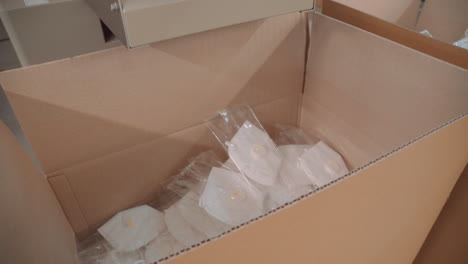 una caja en la que caen máscaras faciales h95 empaquetadas de la línea transportadora