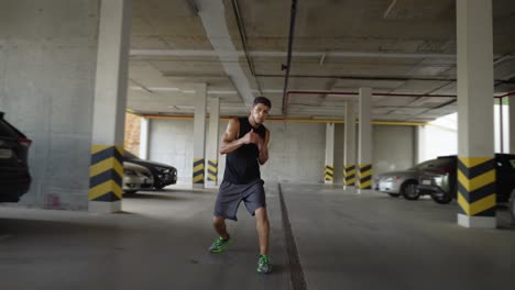 Male-boxer-practicing-punches-in-garage-city