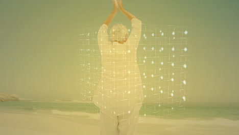 practicing yoga on beach, elderly person with digital animation grid overlay