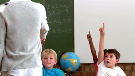 cute pupils lifting their hands in classroom