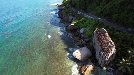 Reveal-drone-shot-of-passing-car-on-cliff-road-Mahe-Seychelles