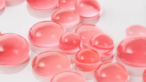 glossy pink spheres and drops on white background