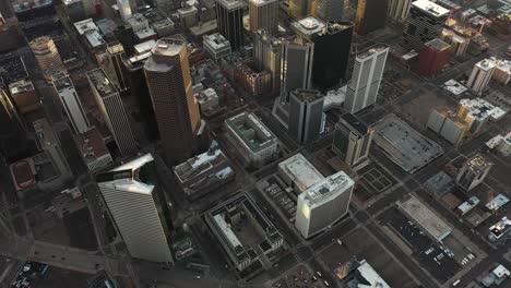 aerial view of downtown denver, central financial district, modern skyscrapers on sunset sunlight, revealing tilt up drone shot